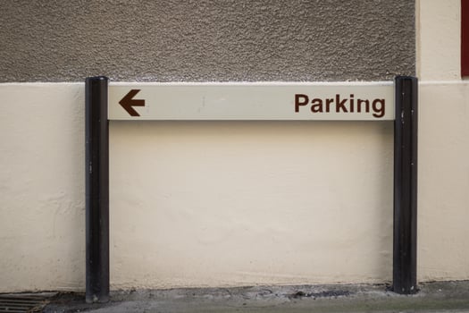 Blue parking sign against a stone wall photo