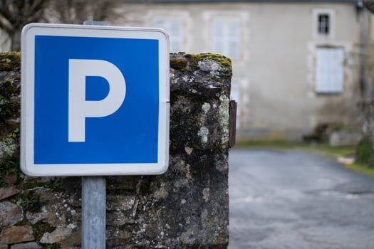 Blue parking sign against a stone wall photo