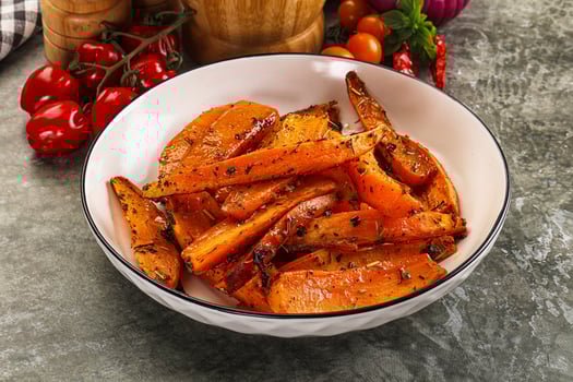 A bowl of carrots and tomatoes on a table photo