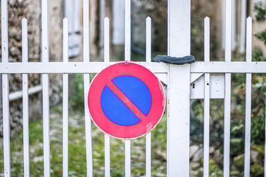 Red and blue no stopping sign on a metallic gate photo