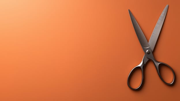 Silver scissors on orange background photo