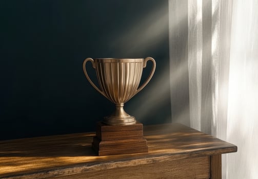 Gold trophy on wooden table in sunlit room photo