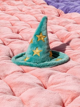 Teal wizard hat on pink fluffy blanket photo