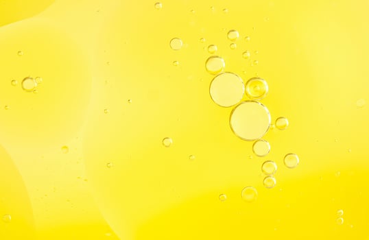 Beautiful cosmetic background. Golden yellow abstract oil bubbles or face serum background. photo