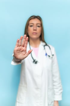 vertical Serious female doctor making stop sign with hand, medical advice and healthcare concept photo