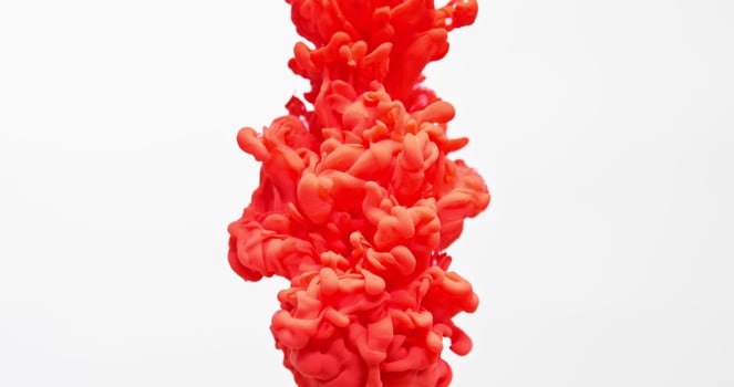 A red liquid is being poured into a glass photo