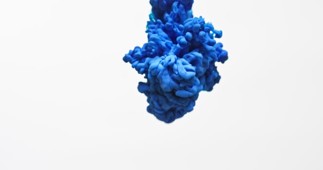 Blue ink in water on white background photo