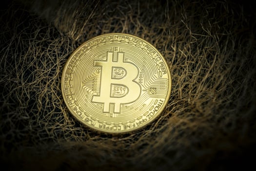 Bitcoin on a fleece of gold threads photo