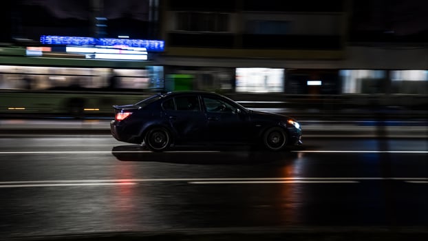 The car drives through the city at night, side view. Motion blur photo