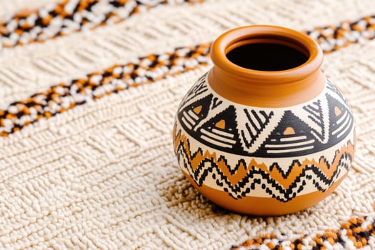 Traditional Native American pottery with geometric patterns displayed on a woven blanket photo