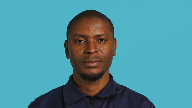 Headshot portrait of security guard at work smiling and overseeing premises. Joyful private law enforcement worker grinning while doing job, close up shot, studio backdrop, camera A photo