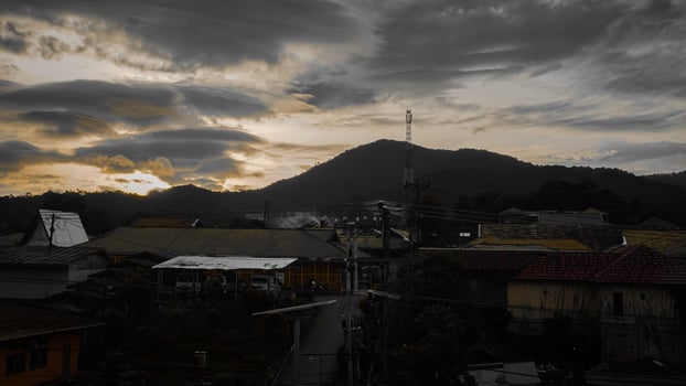 Beautiful Mountain Village at Sunrise with Dramatic Clouds and Scenic Rooftops photo
