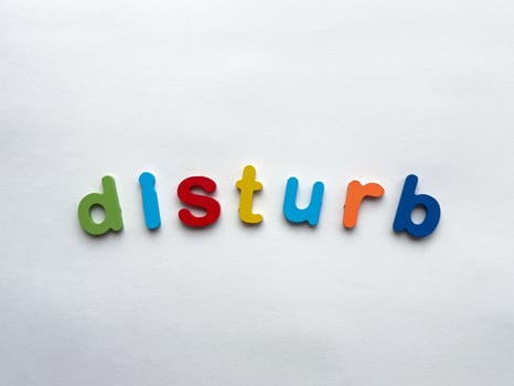 Colorful alphabet letters spell disturb on white background photo