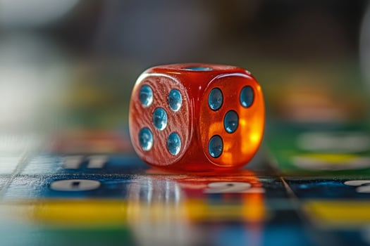 A red dice sitting on a board game photo