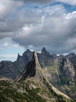 mountain silhouettes and large peaked top in rainy low stormy clouds photo