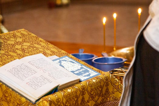A priest is holding a book and a candle photo