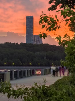 Blurred background of the sunset embankment with people walking along the Moskva River. photo