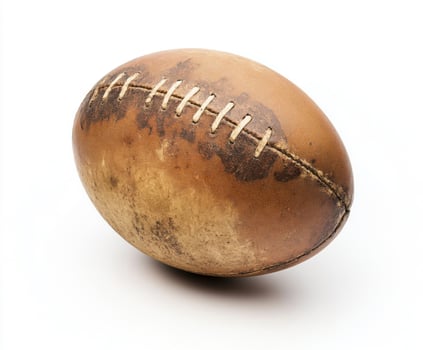 A weathered rugby ball displaying signs of wear and tear on a white background photo