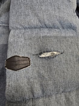 Blue fabric ripped at the sleeve. photo