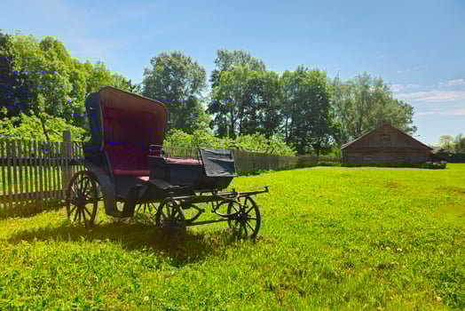 An ancient phaeton carriage on a green rural lawn photo