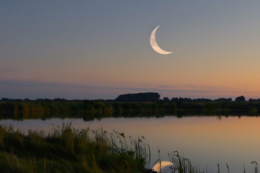 Crescent Moon Over Serene Lake at Sunset Tranquil Nature Scene photo