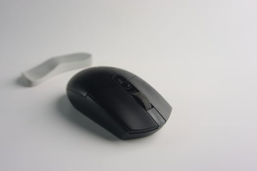 Black Modern Wireless Computer Mouse Placed On White Background Surface photo