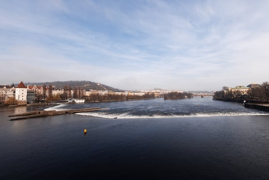 Vltava river flowing showing prague castle on sunny day photo