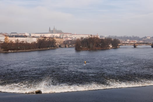 Vltava river flowing with prague castle in background photo