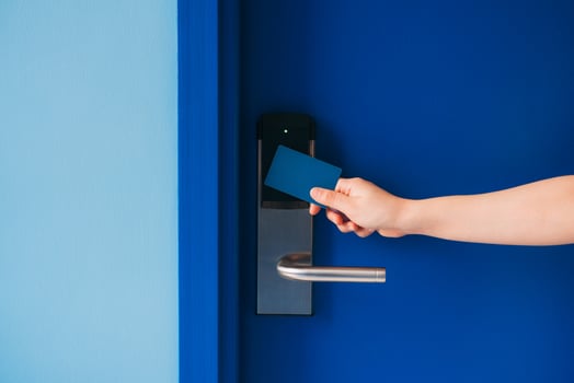 A person holding a credit card to a door photo