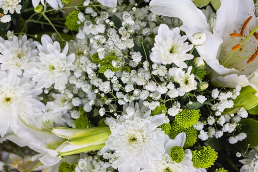 close up of a wedding bouquet with white lilies and green leaves photo