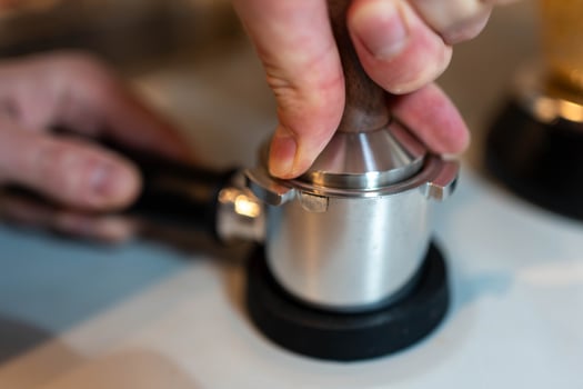 Coffee Preparation. Barista Tamping Espresso Grounds photo