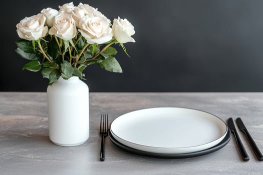 Elegant place setting with white roses and black cutlery photo