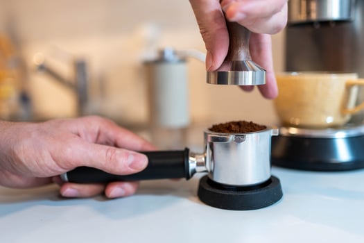 Barista Tamping Freshly Ground Coffee for Espresso photo