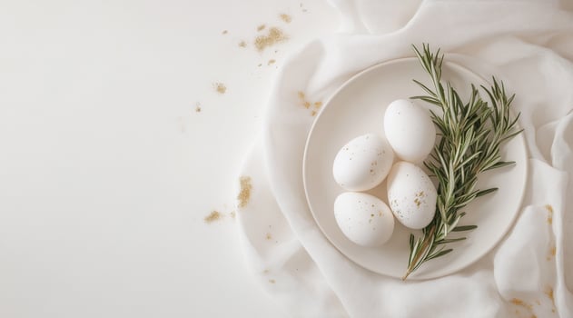 Easter eggs with gold flecks on a pastel plate with rosemary sprigs. Spring-inspired holiday decoration, stylish seasonal setting, modern table decor, festive celebration. photo