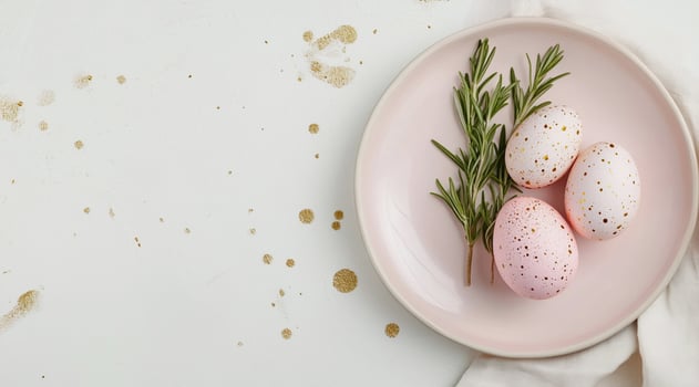 Elegant speckled eggs and rosemary on a blush pink plate for Easter. Minimalist seasonal design, soft natural colors, stylish holiday arrangement, modern festive composition. photo