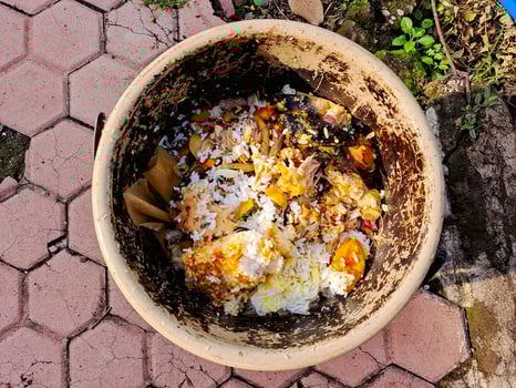 A dirty bowl filled with food on a brick patio photo
