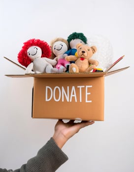 Supporting Others, Open Donation Box with Toy on Clean White Backdrop photo