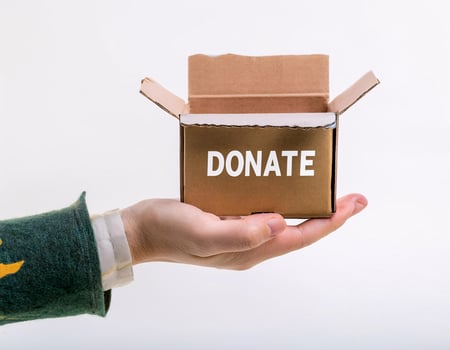 Donation Gesture, Hands Offering Box with Toy Inside on White Background photo