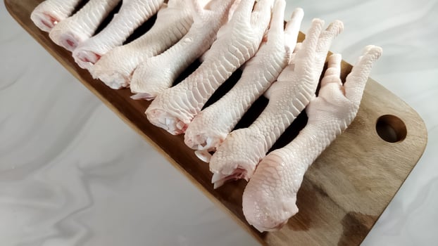 Ceker ayam. Fresh raw chicken feet on a wooden board. Indonesian food. photo