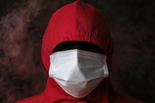 Person in red hooded jacket and white face mask photo