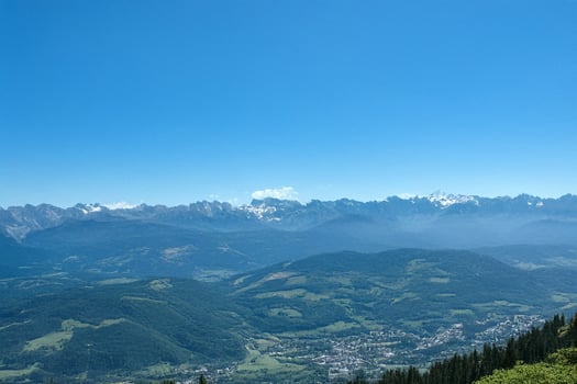 Mountain panorama, valley view, clear sky, distant town, travel poster photo