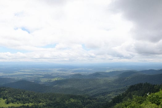 Mountaintop panoramic view cloudy sky, rolling hills, distant valley photo