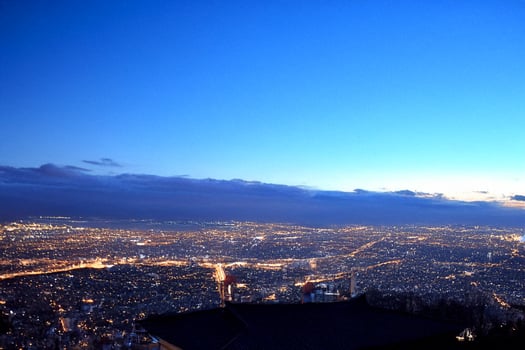 Night city panorama, mountaintop view, twilight sky, urban sprawl, travel photo