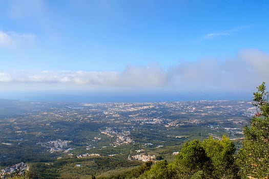 Coastal city panorama from mountaintop, hazy sky photo