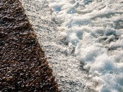 Flowing water texture. White water foam, small waterfall photo