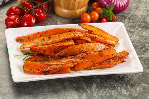 A plate of cooked sweet potatoes with herbs and vegetables photo