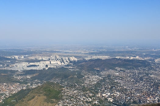 Aerial view sprawling city, mountains, hazy sky, urban sprawl photo
