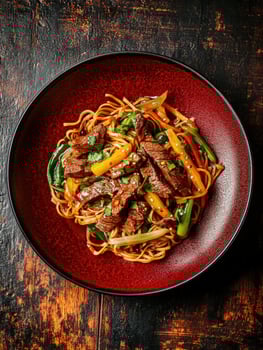 Delicious stir-fried beef noodles with colorful vegetables served in a bowl photo