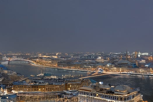Night city panorama, snowy river, bridge, lights photo