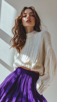 A woman in a purple pleated skirt and white sweater photo